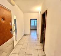 Flur in einer 3-Zimmer-Wohnung mit Fliesen und Eingangstür.