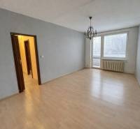 Ein Zimmer mit Holzboden und einem Kronleuchter in einer 3-Zimmer-Wohnung.