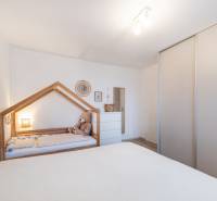 Kinderzimmer in einer Zweizimmerwohnung mit Kinderbett und Schrank.