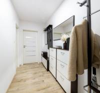 Der Flur in der 2-Zimmer-Wohnung mit einem Boden in Holzoptik, einem Schuhschrank und einer Garderobe.