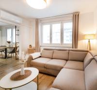 Helles Wohnzimmer in einer 2-Zimmer-Wohnung mit Holzboden und bequemer Couch.