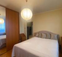 Schlafzimmer in einer 3-Zimmer-Wohnung mit Schrank, Bett und Boden in Holzoptik.