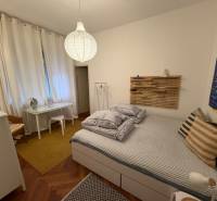 Schlafzimmer in einer 2-Zimmer-Wohnung mit Holzboden und minimalistischer Einrichtung.