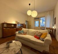 Wohnzimmer in einer Zweizimmerwohnung mit Holzboden und bequemer Couch.