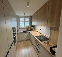 Küche in einer 4-Zimmer-Wohnung mit Küchenzeile, Geräten und Bodenbelag in Holzoptik.