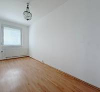 Zimmer in einer 4-Zimmer-Wohnung mit Kronleuchter und Boden in Holzoptik.