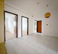 Innenraum einer 4-Zimmer-Wohnung mit weißen Wänden, Fliesen und einem Boden in Holzoptik.