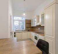 Küche in einer 3-Zimmer-Wohnung mit einem Boden in Holzoptik und klassischen Küchenschränken.