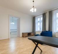 Wohnzimmer in einer 3-Zimmer-Wohnung mit Holzboden und blauer Couch.