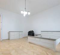 Schlafzimmer mit Bett, Möbeln und Bodenbelag in Holzdekor in einer 3-Zimmer-Wohnung.