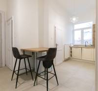 Küche in einer 3-Zimmer-Wohnung mit Bartresen, zwei Stühlen und einem großen Fenster.