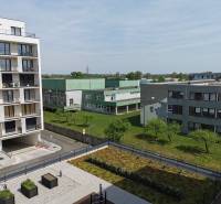 Blick auf Wohngebäude und Grünflächen in Eduard Wenzl in Bratislava-Rača, Garagen rechts.