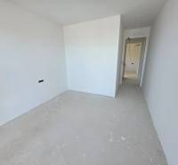 Ferienwohnung mit weißen Wänden und einem einfachen Boden ohne Dekoration.