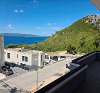 Blick aus der Ferienwohnung in Makarska auf das Meer und die grünen Hügel.