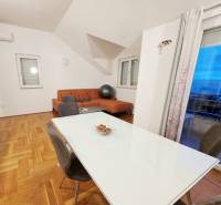 Esszimmer und Wohnzimmer in einem Ferienapartment mit Holzboden.