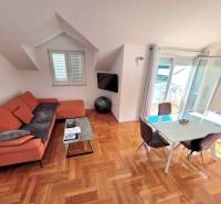 Das Ferienapartment bietet ein Sofa, einen Esstisch und einen Boden mit Holzdekor.