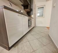 Küche in einer Ferienwohnung mit Fliesenboden und einer modernen Küchenzeile mit dunklen Schränken.