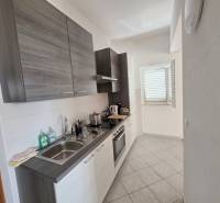 Küche der Ferienwohnung mit moderner Ausstattung und einem Fenster, das den Raum beleuchtet.