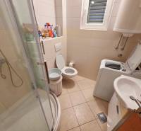 Badezimmer in der Ferienwohnung mit Toilette, Dusche und Waschmaschine.