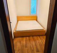 Schlafzimmer in einer 3-Zimmer-Wohnung mit einem Bett und einem Boden in Holzoptik.