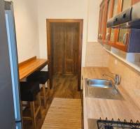 Küche in einer 3-Zimmer-Wohnung mit Holzboden, Bartresen und Geräten.