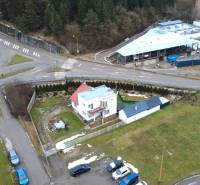 Das Einfamilienhaus in der SNP-Straße in Považská Bystrica, umgeben von Grünflächen und einer Kreuzung.