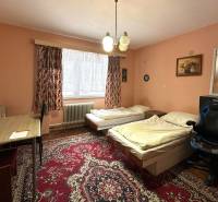 Ein Zimmer in einem Einfamilienhaus mit Teppichboden, zwei Betten und einem Tisch.