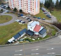 Ein Einfamilienhaus in Považská Bystrica in der Straße SNP, umgeben von einem Parkplatz und Wohnblöcken.