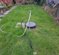 Garten bei der Hütte in Šemša, Rasen mit Brunnen und Schlauch.