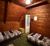 Innenraum einer Hütte mit Holzverkleidung, Betten und Kronleuchter, gemütliche Umgebung zur Entspannung.