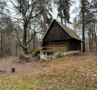 Eine Hütte im Wald mit Holzelementen bei Kováčová, umgeben von Bäumen und Natur.