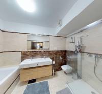 Badezimmer in einer 4-Zimmer-Wohnung mit Badewanne, Dusche und zwei Waschbecken.