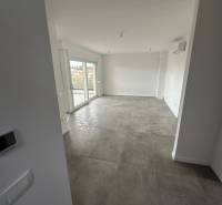 Wohnzimmer in einer 3-Zimmer-Wohnung mit Terrasse und grauen Fliesen.