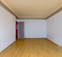 Ein Zimmer in einer 3-Zimmer-Wohnung mit einem Holzboden und weißen Wänden.