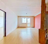 Geräumiges Interieur einer 3-Zimmer-Wohnung mit Holzboden und Balkon.