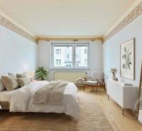 Schlafzimmer mit Bett, Teppich, Sessel, Dekorationen, Boden mit Holzdekor.