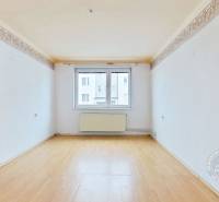 Ein Zimmer mit weißen Wänden und einem Boden in Holzoptik in einer 3-Zimmer-Wohnung.