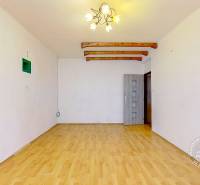 Wohnzimmer in einer 3-Zimmer-Wohnung mit Holzboden und hellem Kronleuchter.