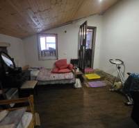 Ein Zimmer in einem Einfamilienhaus mit einem Heimtrainer und einem Boden mit Holzdekor.