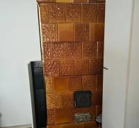 Kachelofen in einem Einfamilienhaus mit einem Boden in Holzoptik.