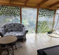 Ein Einfamilienhaus mit einer geräumigen Terrasse, einem bequemen Sofa und einer Schaukel in der Stadt Hont.