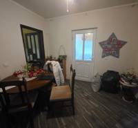 Innenraum eines Einfamilienhauses mit Tisch und Dekorationen, Boden mit Holzdekor.