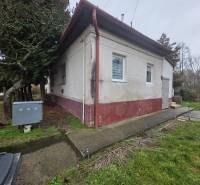 Das Einfamilienhaus in Hont hat eine weiße Fassade, Fenster mit Gittern und Eingangstreppen.