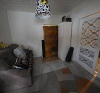 Wohnzimmer in einem Einfamilienhaus mit bequemer Couch und dekorativer Beleuchtung.