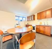 Eine Küche in einem Einfamilienhaus mit Esstisch, Stühlen und einer Küchenzeile mit Holzdekor.