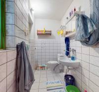 Badezimmer in einem Einfamilienhaus mit hellen Fliesen und bunten Dekorationen.