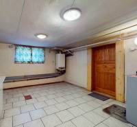 Keller im Einfamilienhaus mit weißen Fliesen auf dem Boden.