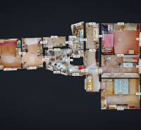 Grundriss eines Einfamilienhauses mit mehreren Zimmern, Küche und Badezimmern, Boden mit Holzdekor.