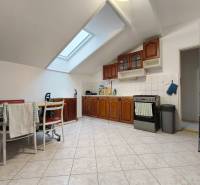 Helle Küche in einem Einfamilienhaus mit Holzschränken und Dachfenster.