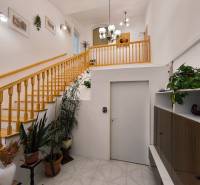 Im Inneren des Einfamilienhauses befindet sich eine Holztreppe, Pflanzen und Leuchten.